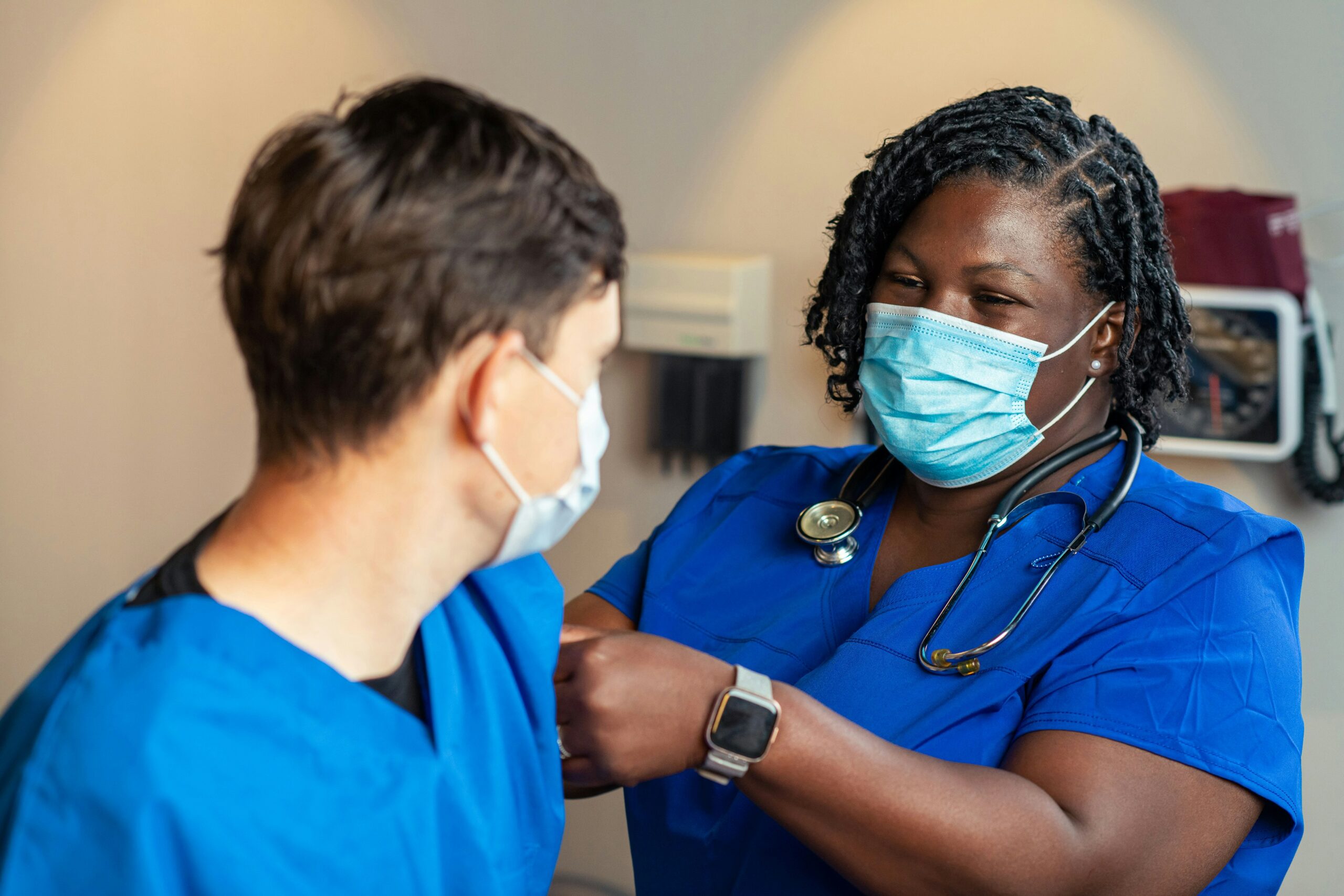 a woman in a blue scrub suit and a man in a blue scrub suit